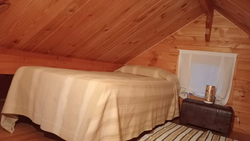 Cama en buhardilla vista lateral en Cabaña Becea